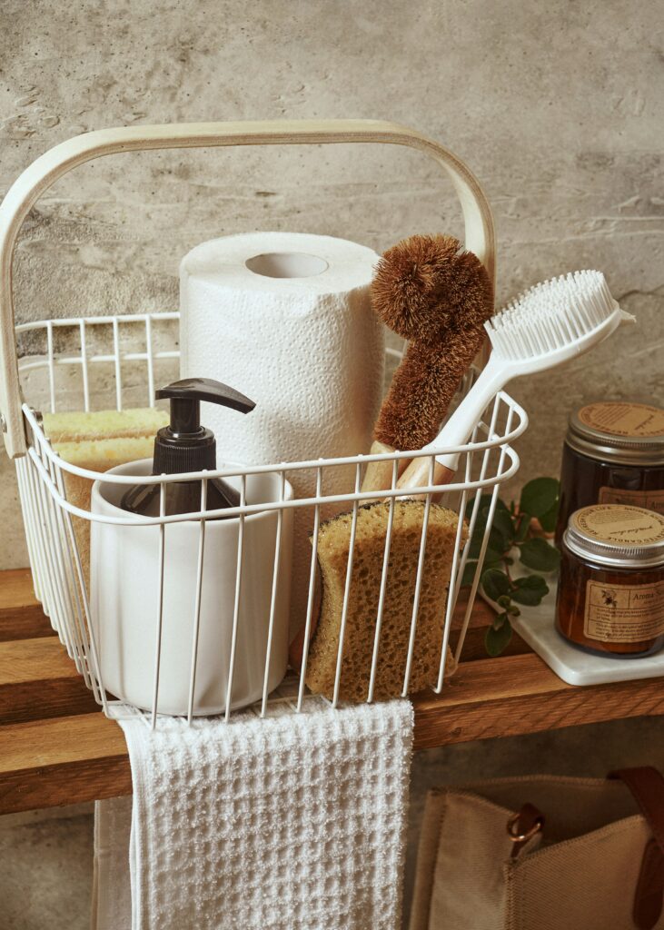 A white basket filled with cleaning supplies.